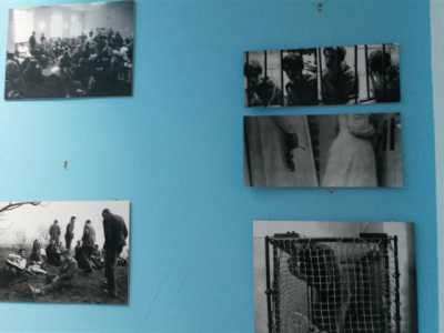 Alcune foto di vecchi manicomi appese al muro lungo la scalinata d'ingresso
